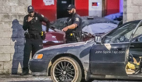 Investigators collect evidence from a Honda Accord that the victim of a shooting may have driven to the 2500 block of Donald Lee Hollowell Parkway.