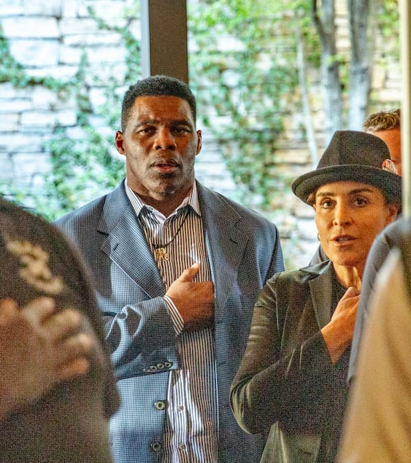 Herschel Walker and his wife, Julie Blanchard, recite “The Pledge of Allegiance” during a September campaign stop at Mojitos Bistro in Norcross. (Jenni Girtman for The Atlanta Journal-Constitution)