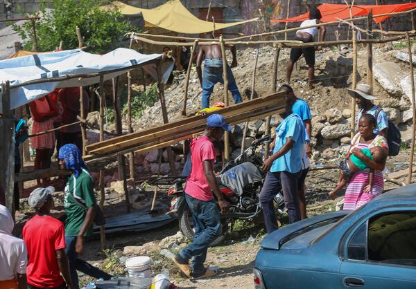 Residents of the Nazon neighborhood displaced by gang violence construct a tent encampment, in Port-au-Prince, Haiti, Friday, Nov. 15, 2024. (AP Photo/Odelyn Joseph)