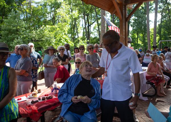 Avondale Estates postal clerk Russel Lewis (right) greets Bonnie Benedict (left) during a retirement party for Lewis on Wednesday, June 30, 2021, at Willis Park in Avondale Estates, Georgia. The Avondale community threw the gathering in honor of Lewis who served at the Avondale post office for 25 years.  CHRISTINA MATACOTTA FOR THE ATLANTA JOURNAL-CONSTITUTION.