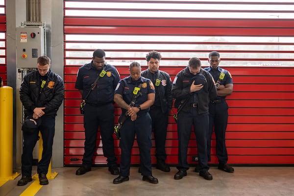 Members of the Atlanta Fire Rescue Department join in an opening prayer at the celebration of the city's new fire station in southwest Atlanta on Feb. 9, 2024.