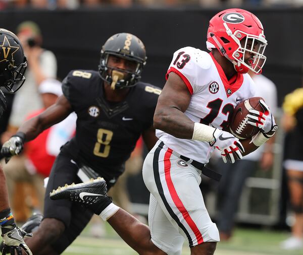 October 7, 2017 Nashville: Georgia tailback Elijah Holyfield breaks away from Vanderbilt defender Joejuan Williams for a touchdown to take a 45-7 lead during the fourth quarter in a NCAA college football game on Saturday, October 7, 2017, in Nashville.   Curtis Compton/ccompton@ajc.com