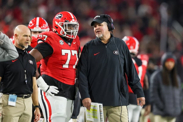 Georgia offensive lineman Earnest Greene III (left) talks with offensive line coach Stacy Searels on Nov. 25, 2023, against Georgia Tech at Bobby Dodd Stadium. Jason Getz/AJC 2023