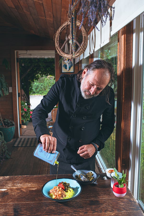 Executive chef and owner Mark Henegan of the Bush Farmhouse finishes hoppin' John with a drizzle of olive oil. (Grace Dickinson for The Atlanta Journal-Constitution)