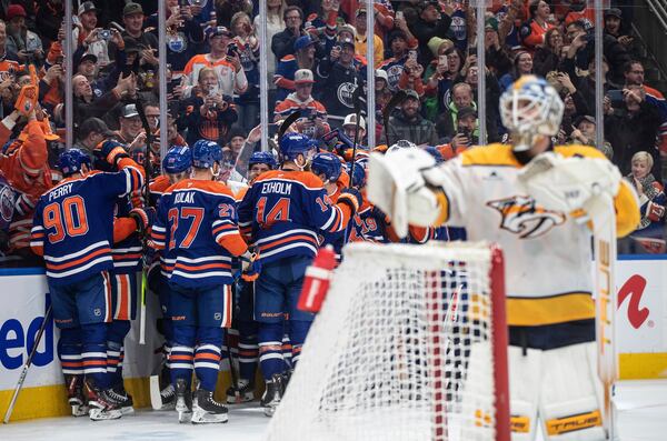 Edmonton Oilers' Connor McDavid (hidden) celebrates his 1000th point with teammates, against the Nashville Predators during the second period of an NHL hockey game, Thursday, Nov. 14, 2024 in Edmonton, Alberta. (Jason Franson/The Canadian Press via AP)