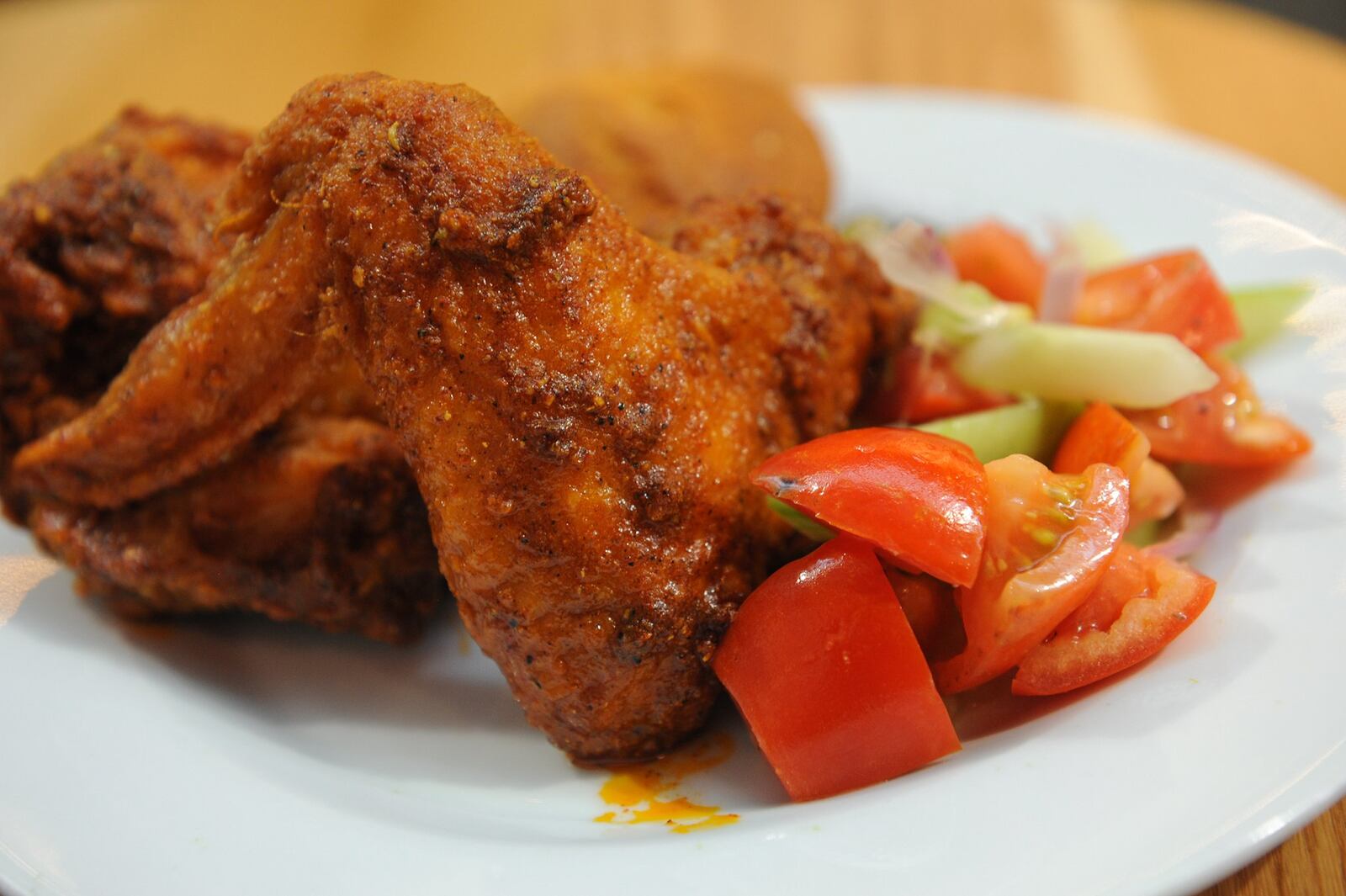 Spicy breast and wing with potato wedges and cucumber and tomato salad. (BECKY STEIN PHOTOGRAPHY)