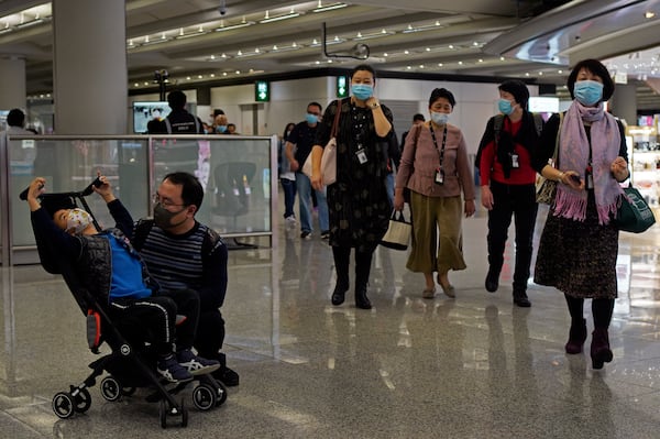 Passengers wear masks as they walk at the Hong Kong International Airport on Saturday.