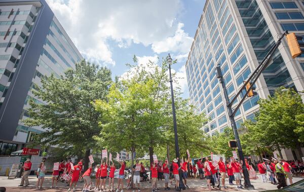 Workers hold signs during a Communications Workers of America rally outside of AT&T's offices on Saturday, August 3, 2019, in Atlanta.  BRANDEN CAMP/SPECIAL