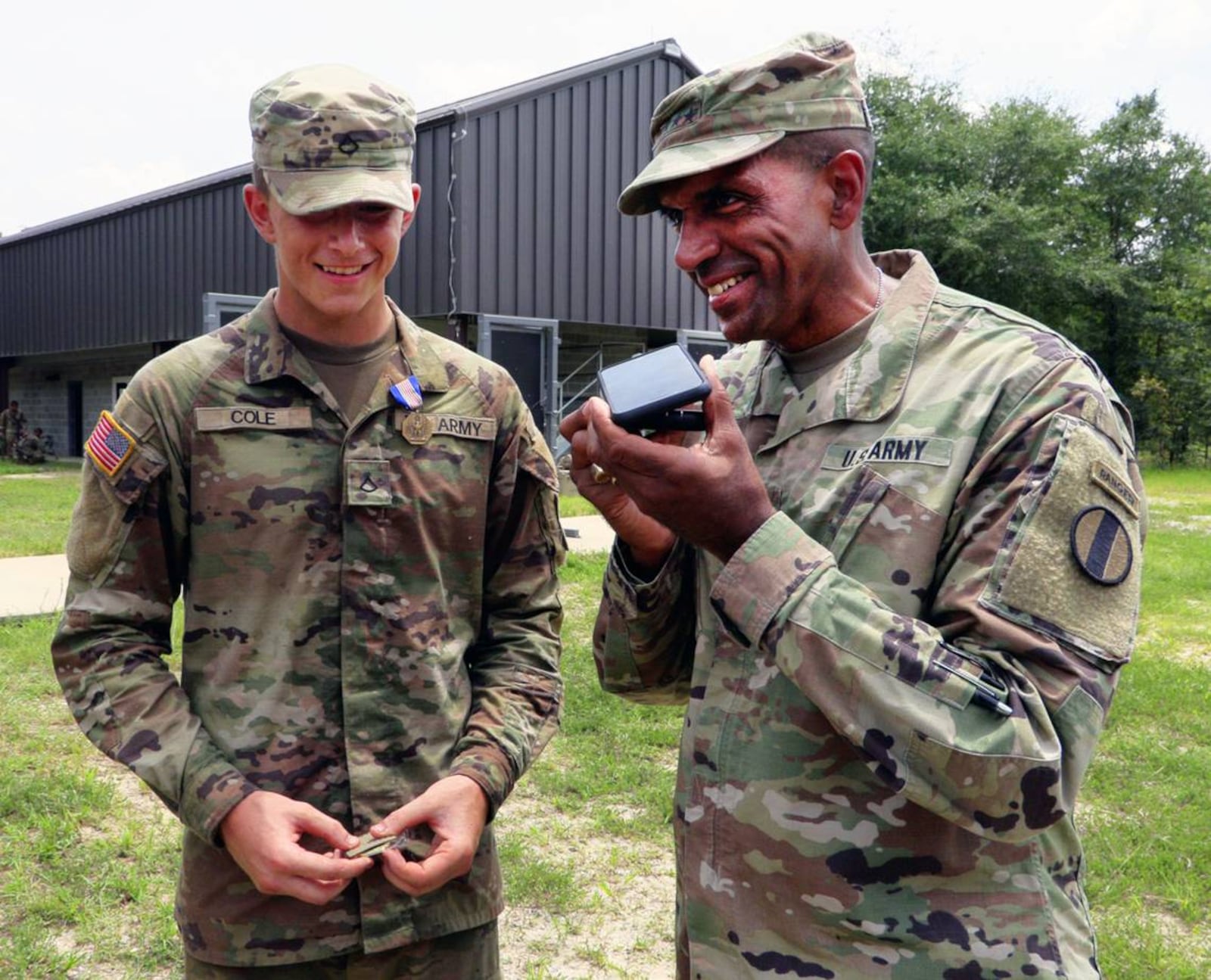 Gen. Gary Brito, commander of the Army’s Training and Doctrine Command, right, and Pvt. Matthew Cole, left, speak with Cole’s father after a ceremony Tuesday at Fort Moore where Pvt. Cole was presented with the Soldier’s Medal for his heroic actions that saved a 3-year-old girl and her father from the rising Chattahoochee River while he was off duty May 26 in Columbus. (Photo Courtesy of Mike Haskey)