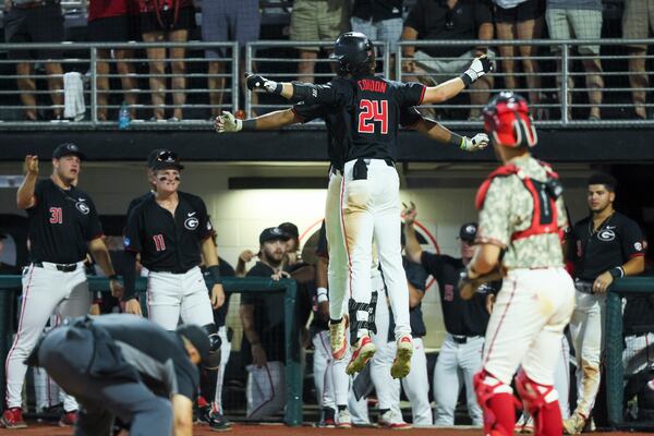 Georgia third baseman Charlie Condon (24) celebrates his solo home run with a teammate during the ninth inning against N.C. State in Game 3 of the NCAA Super Regional at Foley Field, Monday, June 10, 2024, in Athens, Ga. This was Condon’s 37th home run of the season. Georgia lost 8-5. (Jason Getz / AJC)
