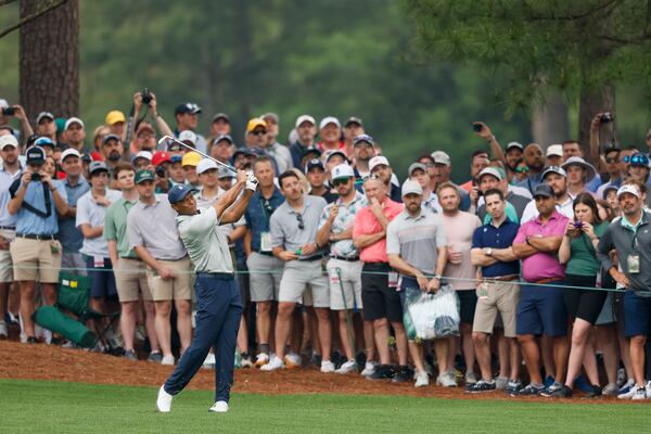 Tiger Woods hits his second shot on the ninth fairway next to patrons during the practice round for the 2023 Masters Tournament at Augusta National Golf Club, Tuesday, April 4, 2023, in Augusta, Ga. Jason Getz / Jason.Getz@ajc.com)
