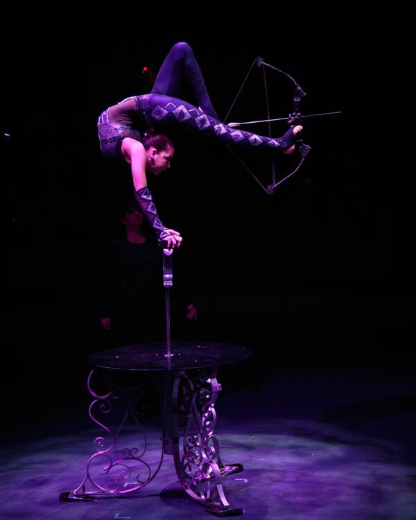 Contortionist Elayne Kramer fires a bow and arrow with her feet while balancing on a table during a recent performance of the Big Apple Circus, which will be in Alpharetta through Feb. 25. STEVE SCHAEFER / SPECIAL TO THE AJC