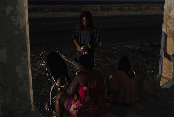 Residents wait outside on a street during a general blackout in Havana, Cuba, Friday, March 14, 2025. (AP Photo/Ramon Espinosa)