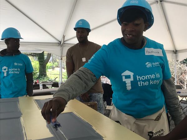 East Lake resident Krushetta Holt is moving to a new Habitat home in Sylvan Hills in a couple of months near Fort McPherson. Here she is painting her front door yellow. 