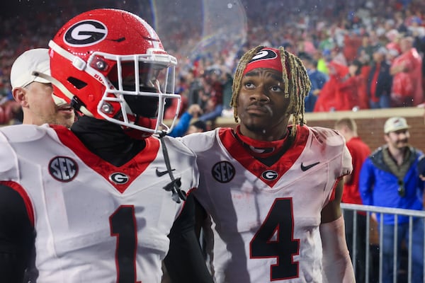 Georgia defensive back Ellis Robinson IV (1) and Georgia defensive back KJ Bolden (4) walk off of the field as Mississippi fans storm the field after Georgia’s loss to Mississippi at Vaught Hemingway Stadium, Saturday, November 9, 2024, in Oxford, Ms. Mississippi won 28-10. (Jason Getz / AJC)
