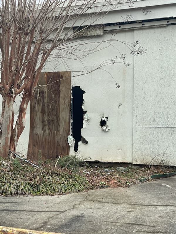 One of the buildings at the Sprayberry Crossing shopping center in East Cobb has been targeted by vandals. A developer is in talks to purchase the shopping center at the northeast corner of Sandy Plains and East Piedmont roads and build apartments and space for a grocery store. Credit: Joe Glancy