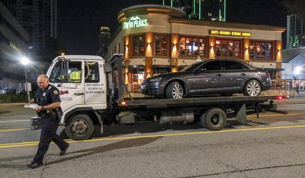 Police tow away a car on Piedmont Road in Buckhead on Feb. 23, 2018. The car had been driven by a man who was followed and shot that morning. Investigators said the man managed to drive himself to a Hampton Inn on Piedmont Road and call 911. (JOHN SPINK/JSPINK@AJC.COM)