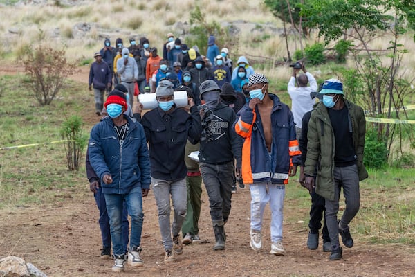 Volunteer rescue workers and community members leave a mine shaft where illegal miners are trapped in a disused mine in Stilfontein, South Africa, Thursday, Nov.14, 2024. (AP Photo/Jerome Delay)