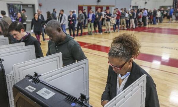 Chandra Brown votes after a long wait Tuesday at Grady High School. JOHN SPINK / JSPINK@AJC.COM