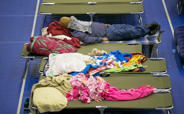 People try to take a nap before dinner is served Saturday at the Wilhelmina Delco Center in East Austin, which has been opened as an evacuee shelter for those fleeing their homes in the path of Hurricane Harvey. RALPH BARRERA / AMERICAN-STATESMAN