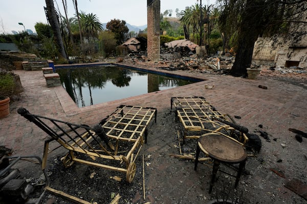 Burned outdoor furniture is left behind on a property after the Franklin Fire swept through, Wednesday, Dec. 11, 2024, in Malibu, Calif. (AP Photo/Damian Dovarganes)