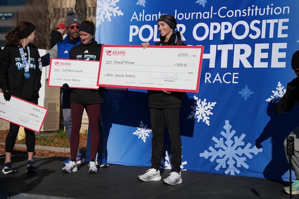 First place female winner Laura Pifer, 40, of Suwanee accepts her prize check.