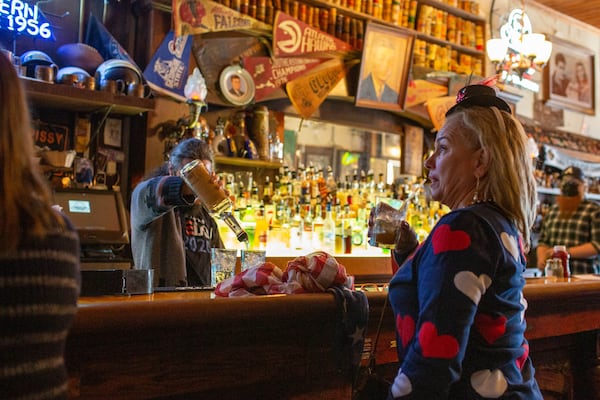 Kelsey Nix watches the inauguration of Joe Biden at an inauguration watch party at Manuel's Tavern in Atlanta on Wednesday. (Rebecca Wright for the Atlanta Journal-Constitution)