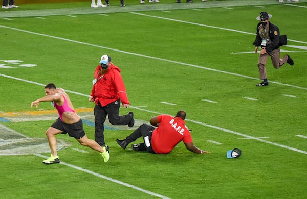 Andrade breaks free from security guards after sprinting on the field during Super Bowl 55. (Arielle Bader/Tampa Bay Times/TNS)