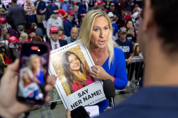 U.S. Rep. Marjorie Taylor Greene, R-14th district, holds a sign with a photo of slain nursing student Laken Riley while being interviewed at a rally for presidential candidate and former president Donald Trump in Rome on Saturday, March 9, 2024. (Arvin Temkar / arvin.temkar@ajc.com)