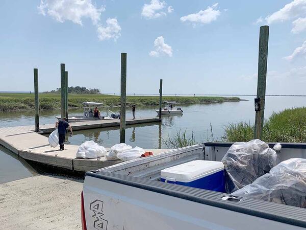 Booms with oil collected from the waters off St. Simons Island sit in the back of a pickup Monday.