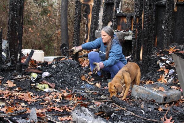 Sandy Lyndon digs through the debris of her tiny house after it burned to the ground on Nov. 27. ELLEN ELDRIDGE / ELLEN.ELDRIDGE@AJC.COM