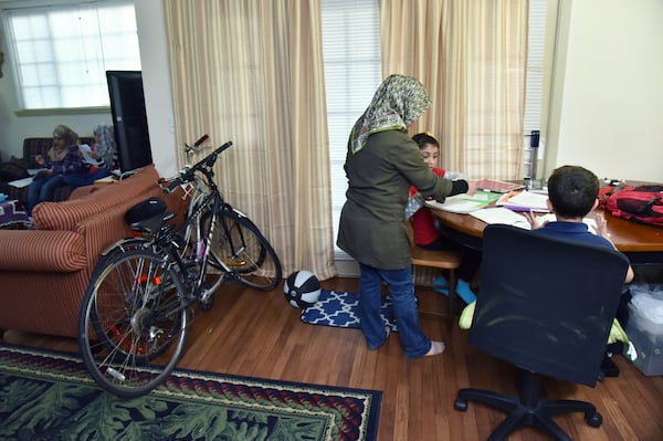 Barwin Musa helps her children with their homework at their Clarkston apartment on April 13, 2017. HYOSUB SHIN / HSHIN@AJC.COM