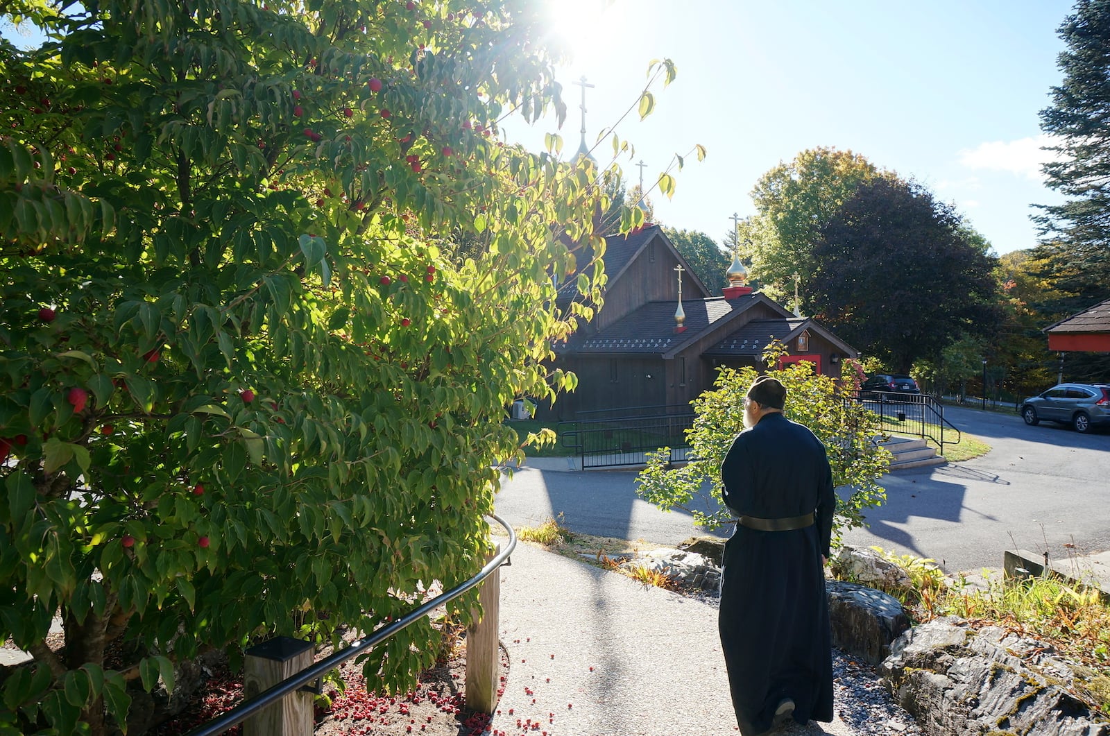 Brother Luke, an Orthodox Christian monk, walks toward the Church of Holy Transfiguration, the first church built by the brothers in 1970 for the New Skete monastery, which runs both a dog breeding and a dog training program outside Cambridge, N.Y., on Oct. 12, 2024. (AP Photo/Giovanna Dell’Orto)