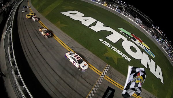 Denny Hamlin (11) collects the checkered flag during a wild finish of the Monster Energy NASCAR Cup Series 61st Annual Daytona 500 Sunday, Feb. 17, 2019, at Daytona International Speedway in Daytona Beach, Fla.