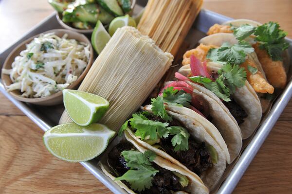 141125-ATLANTA-GA- John Kessler's dining review of Bartaco on Tuesday November 25, 2014. FOOD: Small Tray - Chef's selection of tacos- 2 baja fish, 2 chicken, 2 pork belly served with tamales, spicy cucumber salad and chipotle slaw. (Beckysteinphotography.com) Combination of tacos, tamales and sides