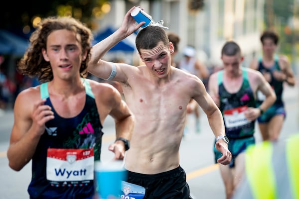 A runner dumps water on his head during the 55th running of the Atlanta Journal-Constitution Peachtree Road Race at "Cardiac Hill" on Peachtree Road NW in Atlanta on Thursday, July 4, 2024. (Seeger Gray / AJC)