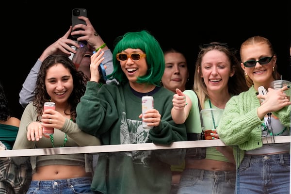 Spectators watch the St. Patrick's Day parade from a balcony, Sunday, March 16, 2025, in Boston, Mass. (AP Photo/Robert F. Bukaty)