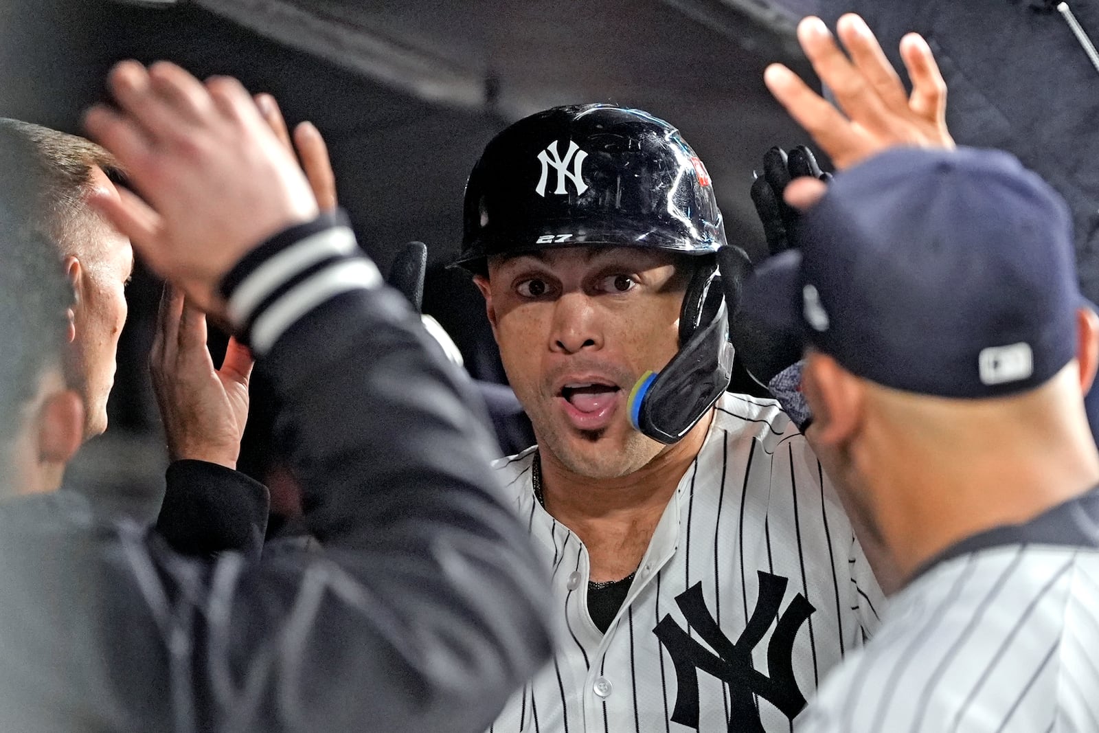 New York Yankees' Giancarlo Stanton celebrates in the dugout after hitting a home run against the Cleveland Guardians during the seventh inning in Game 1 of the baseball AL Championship Series Monday, Oct. 14, 2024, in New York. (AP Photo/Godofredo Vásquez )