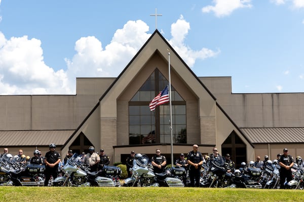 Law enforcement officers watch a funeral procession for Carroll County Investigator Taylor Bristow at Mount Holly Church in Carrollton on Thursday. (Arvin Temkar / AJC)