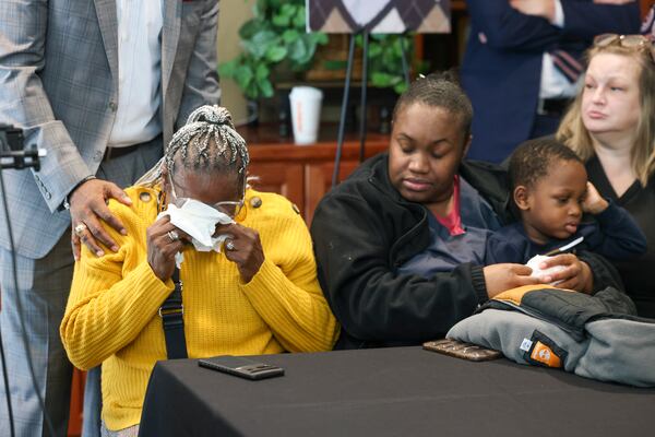 Chandra Toland, left, reacts during a press conference for her late son Dino Walker, a Fulton inmate, who was stabbed to death at the Fulton County Jail in 2022 at the office of Davis Bozeman Johnson Law, Thursday, September 21, 2023, in Decatur, Ga. Also pictured; is Quenteesha Parks and her two-year-old son D’claire Walker, Dino’s son. (Jason Getz / Jason.Getz@ajc.com)