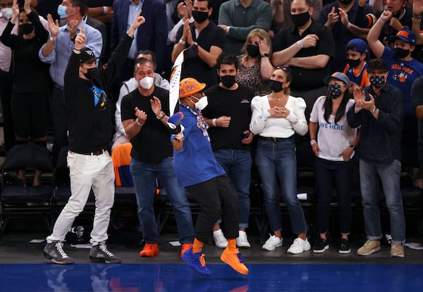 Spike Lee, in orange hat, celebrates late in the fourth quarter of Game 2 in an NBA basketball first-round playoff series between the Atlanta Hawks and the New York Knicks on Wednesday, May 26, 2021, in New York. (Elsa/Pool Photo via AP)