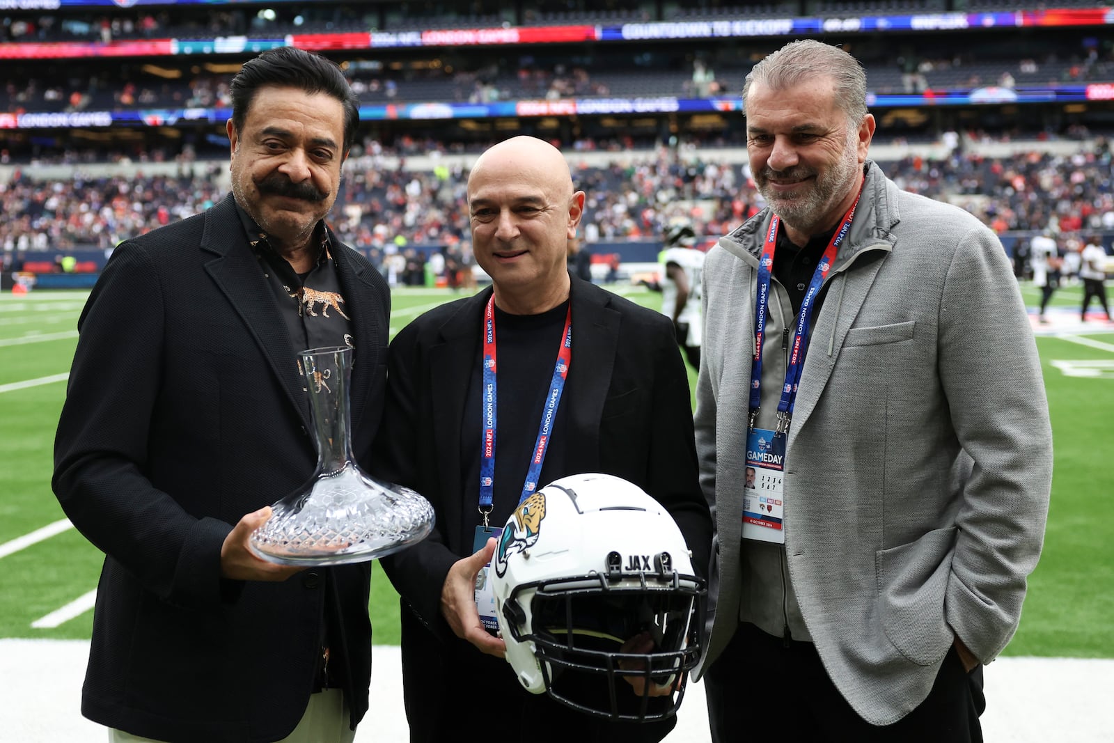 Jaguars owner Shahid Khan, Tottenham chairman Daniel Levy and Spurs head coach Ange Postecoglou, from left, pose for a photo before an NFL football game at the Tottenham Hotspur stadium between the Jacksonville Jaguars and Chicago Bears in London, Sunday, Oct. 13, 2024. (AP Photo/Ian Walton)