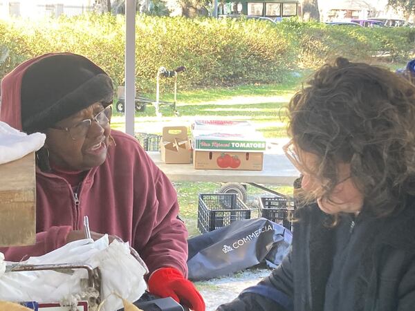 Helen Fields (left) talks with a customer at the Fields Farm tent at the Forsyth Farmers Market. Fields Farm is a 50-acre organic farm located in Johns Island, South Carolina near Charleston. (Adam Van Brimmer/adam.vanbrimmer@ajc.com)