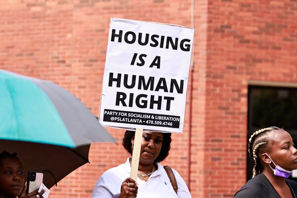 Eve Mayo, a nine-year resident of Forest at Columbia Apartments holds a “housing is a human right” sign during a rally outside of the DeKalb Government Building on Thursday, July 28, 2022. (Natrice Miller/AJC 2022)