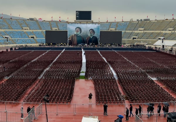 Photographers take pictures of workers setting up the chairs at Beirut's City Sportive stadium during preparation a day ahead of the funeral procession of Hezbollah leaders Sayyed Hassan Nasrallah and Sayyed Hashem Safieddine, in Beirut, Lebanon, Saturday, Feb. 22, 2025. (AP Photo/Hussein Malla)