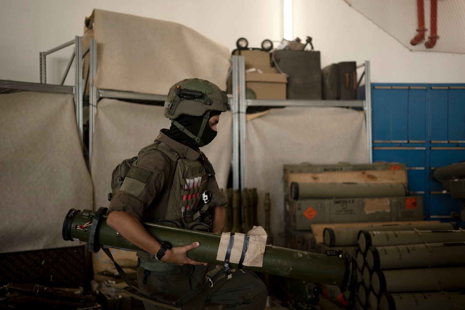 An Israeli soldier from an EOD (explosive ordnance disposal) unit moves a weapon used by Hezbollah seized during combat operations in Lebanon displayed during a government-organized media tour on a base in southern Israel, Wednesday, Oct. 9, 2024. (AP Photo/Maya Alleruzzo)