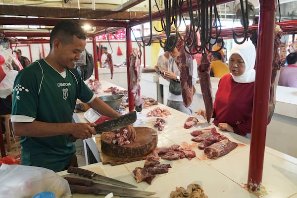 FILE - A butcher serves a customer at a market in Jakarta, Indonesia, Wednesday, March 22, 2023, during preparations to welcome the holy month of Ramadan, expected to start the following day. (AP Photo/ Ahmad Ibrahim, File)