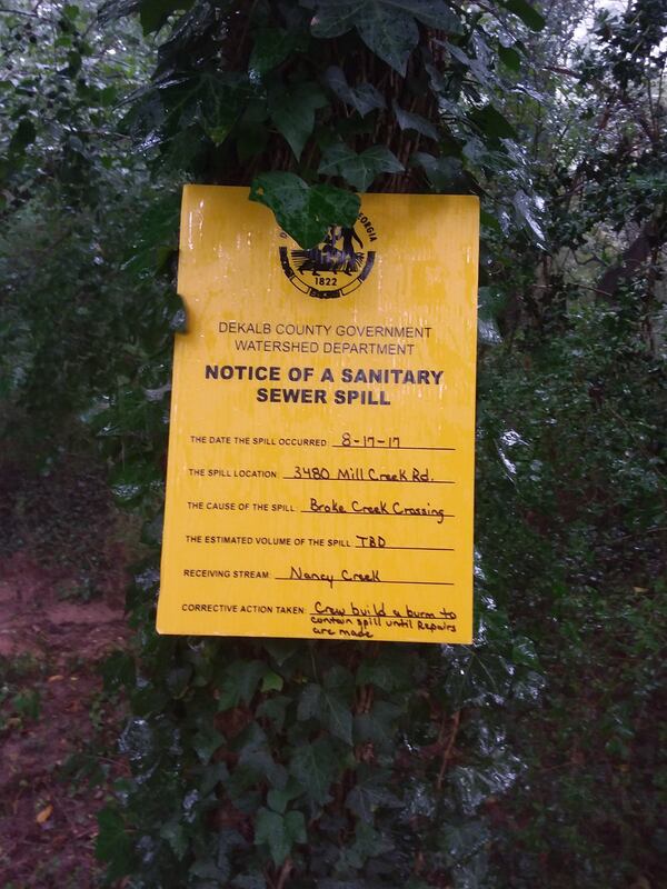 Signs notifying residents of a major sewage spill were posted on Mill Creek Road. A sewer line broke near a tributary to Nancy Creek in Brookhaven, spilling millions of gallons of sewage. It’s the largest spill in DeKalb County in more than a decade. Photo credit: DeKalb County