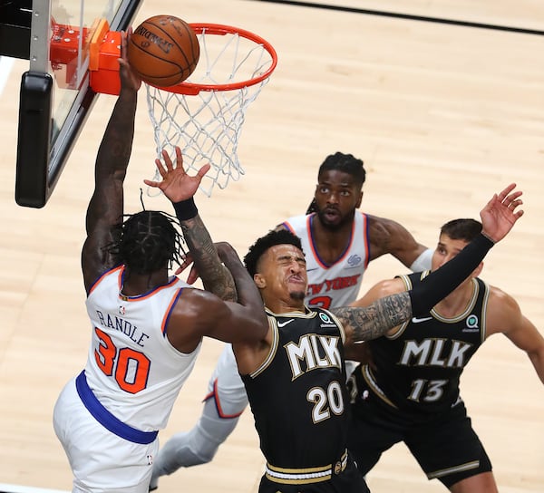 Hawks forward John Collins takes an elbow in the face having to leave the game with a bloody mouth for medical attention on a foul from New York Knicks forward Julius Randle during Game 4 of their first-round NBA playoff matchup Sunday, May 30, 2021, at State Farm Arena in Atlanta. (Curtis Compton / Curtis.Compton@ajc.com)