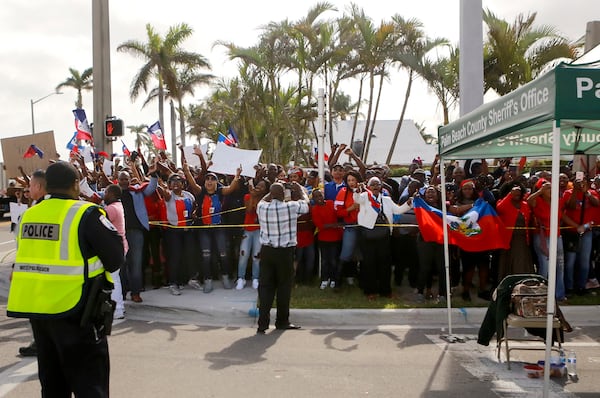 Protesters line Southern Boulevard as President Donald Trump's motorcade passes on its way to Mar-a-Lago Monday afternoon, January 15, 2018. (Bruce R. Bennett / The Palm Beach Post)